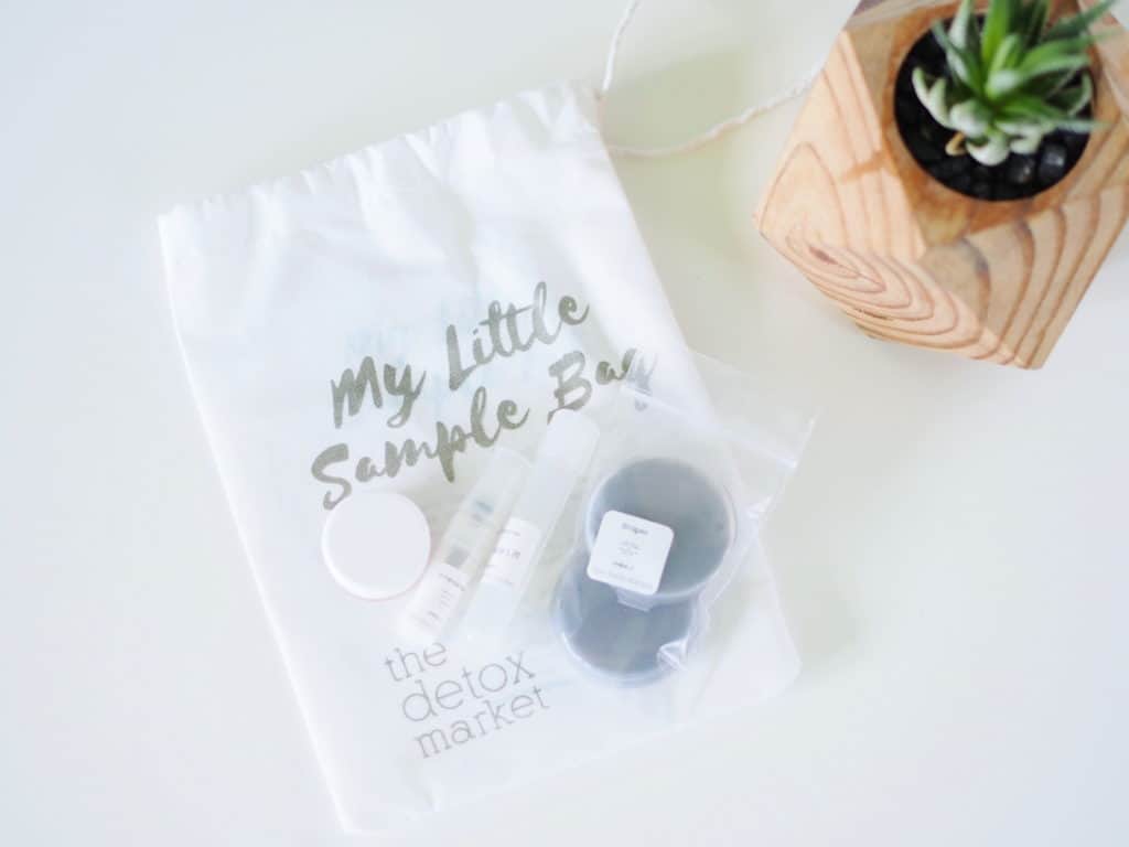 Green organic skincare samples shown on table with bag and plant