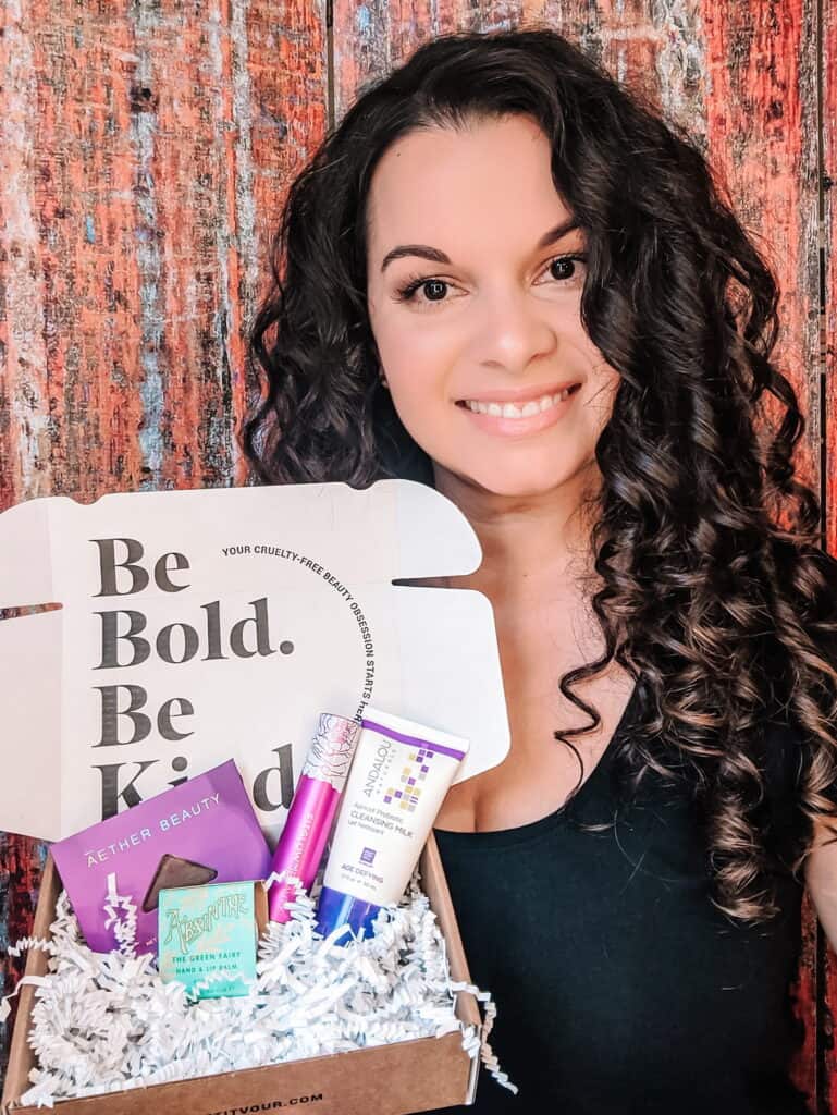 Delilah holding some of her favorite green organic skincare and makeup samples