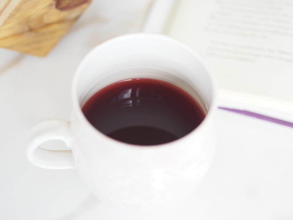 Manuka Honey in tea for colds or strep on counter with book in background