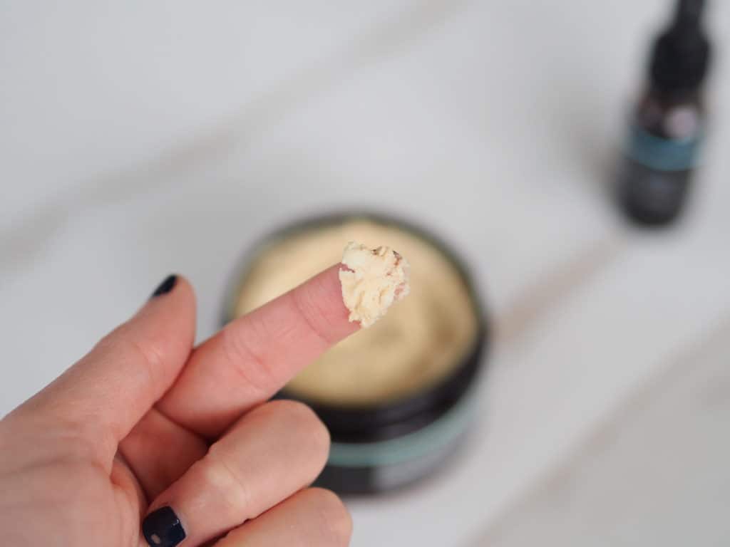 Delilah's finger with a small amount of nontoxic body lotion product on her finger