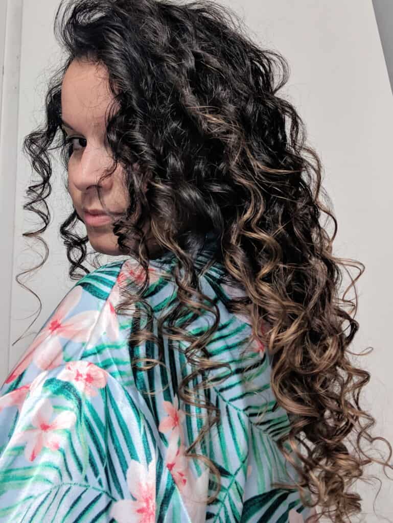 Delilah Orpi in patterned robe turned to show long curls after using curly girl method approved products deep conditioner