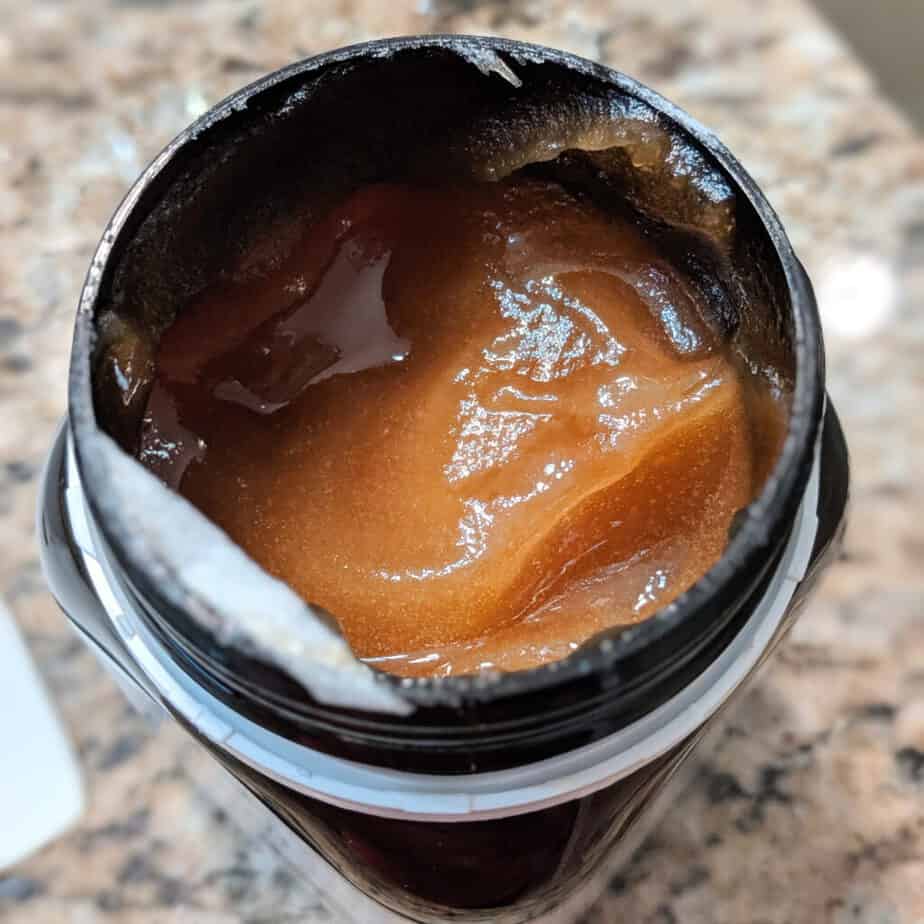 Open jar of manuka honey for scalp 