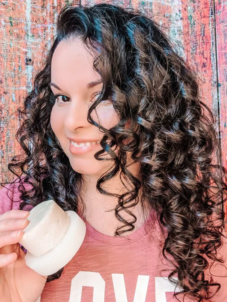 Delilah smiling while holding Vida Clarity shampoo bars two of her favorite curly girl approved products of 2020