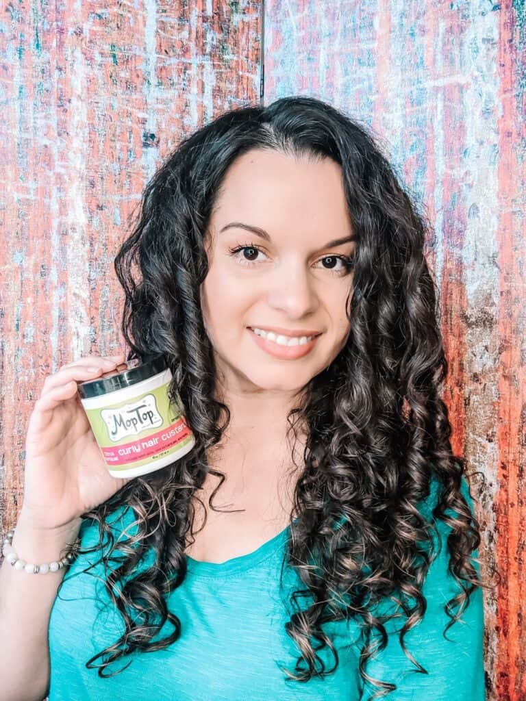 Delilah holding MopTop Curly Custard curly hair method products