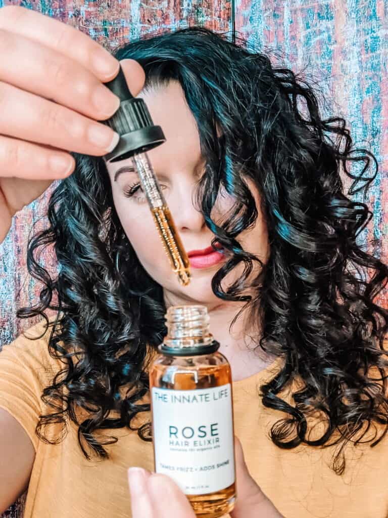 The Innate Life Rose Hair Elixir oil held by Delilah