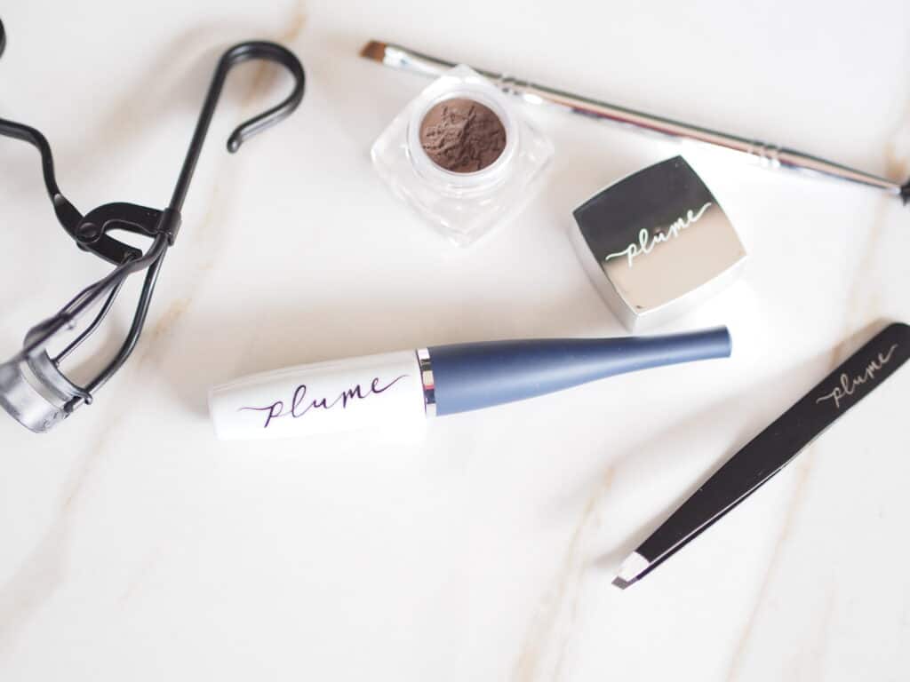 Plume lash and brow products displayed on a counter