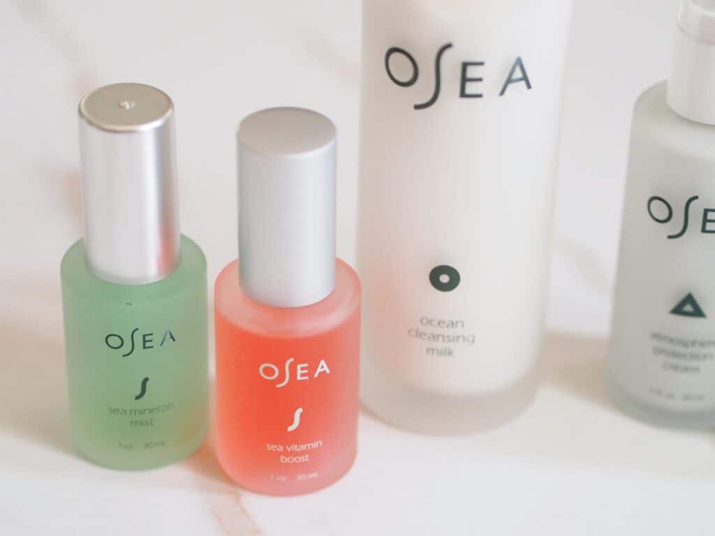 OSEA products toners sea mist cleansing milk in glass bottles on counter that help with glowing summer skin