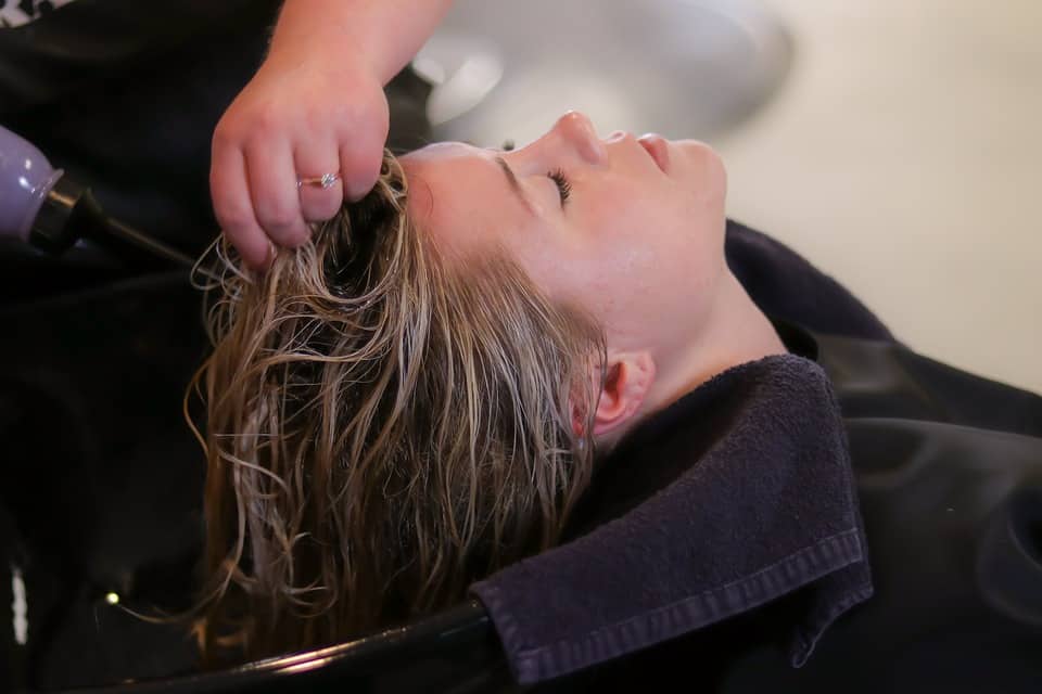 woman in salon chair getting deep conditioner treatment for Dominican Blowout