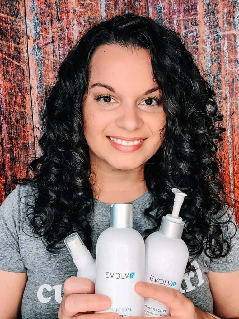 holding up EVOLVh conditioner for curly hair