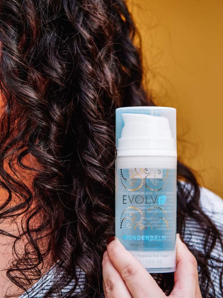 EVOLVh WonderBalm Magic For Curls bottle next to curly hair