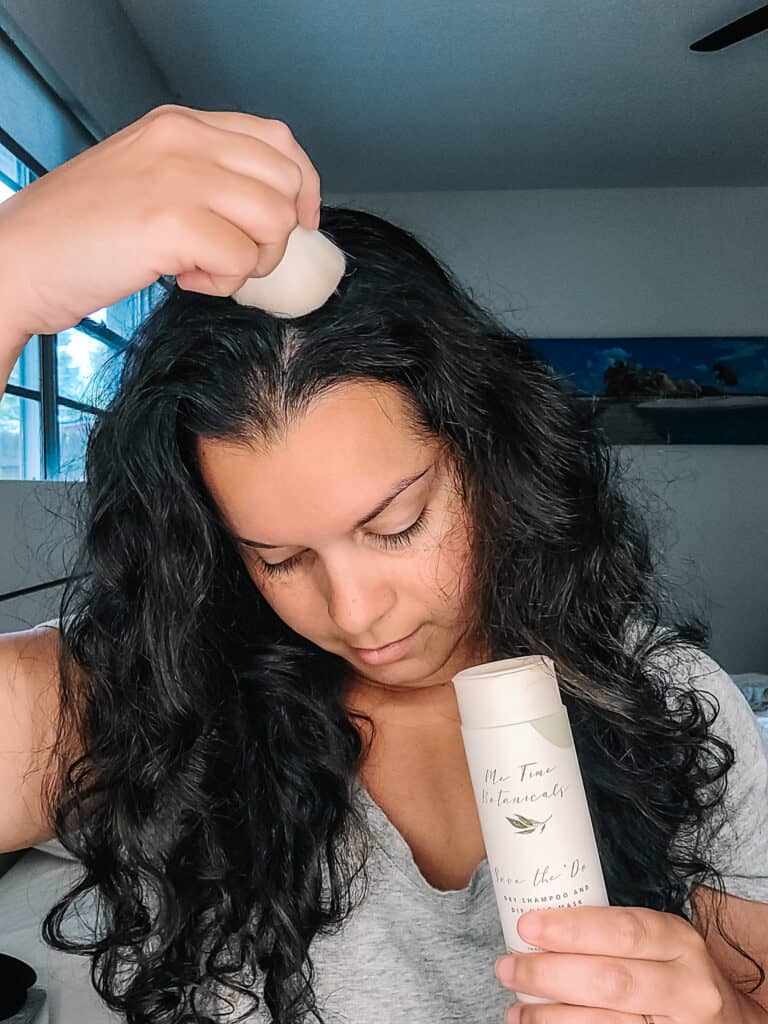 applying powder dry shampoo to curly hair