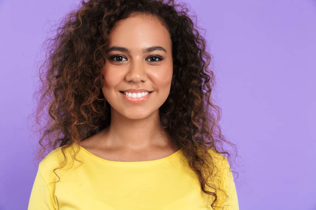 woman with medium length fluffy curly hair smiling