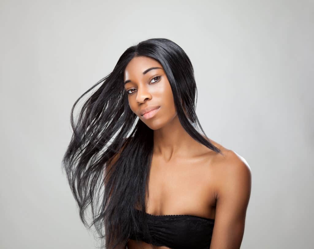 smiling Black woman with long straight hair
