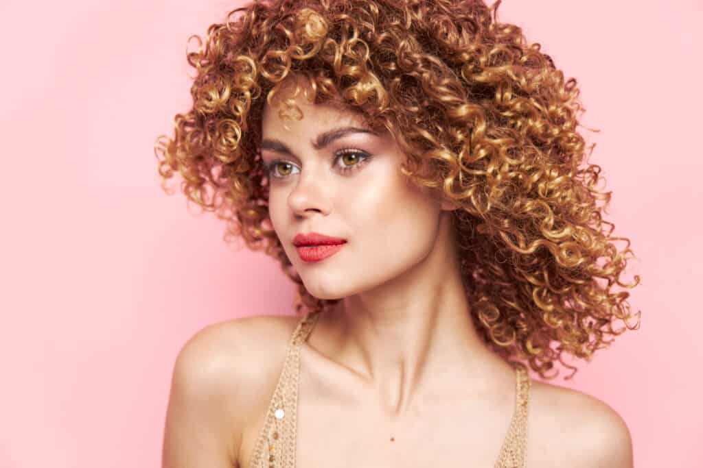 guide to copper hair color dye - woman with curly copper hair