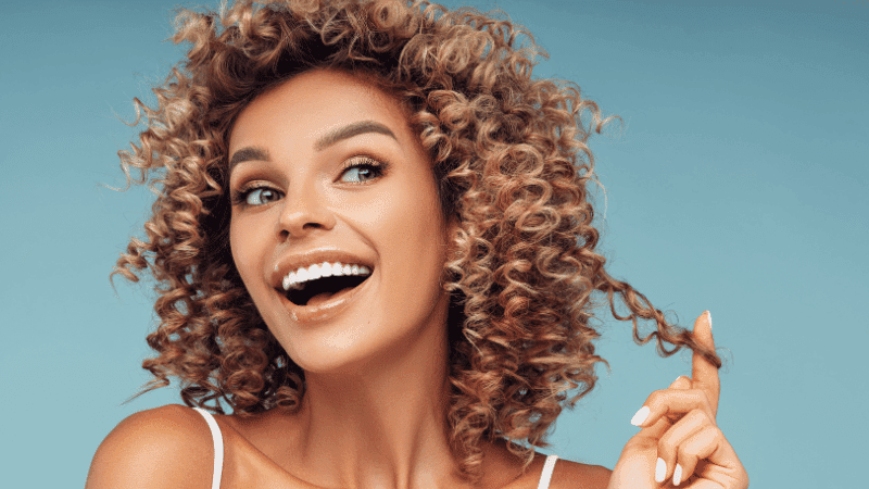 best leave in conditioner for curly hair woman with curly hair smiling