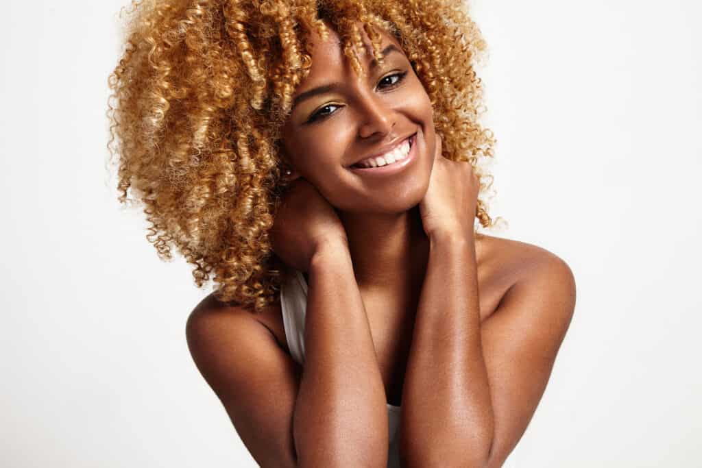 young black woman with blond curly hair that used Wella T14 Toner