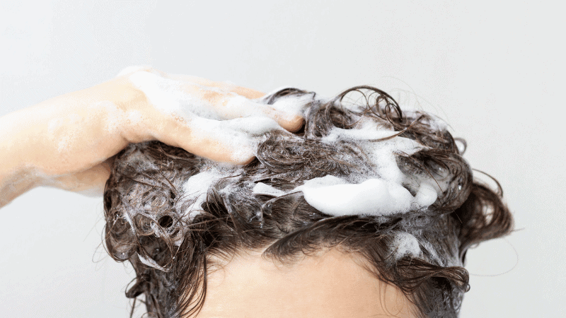 woman shampooing hair with shampoo for low porosity hair