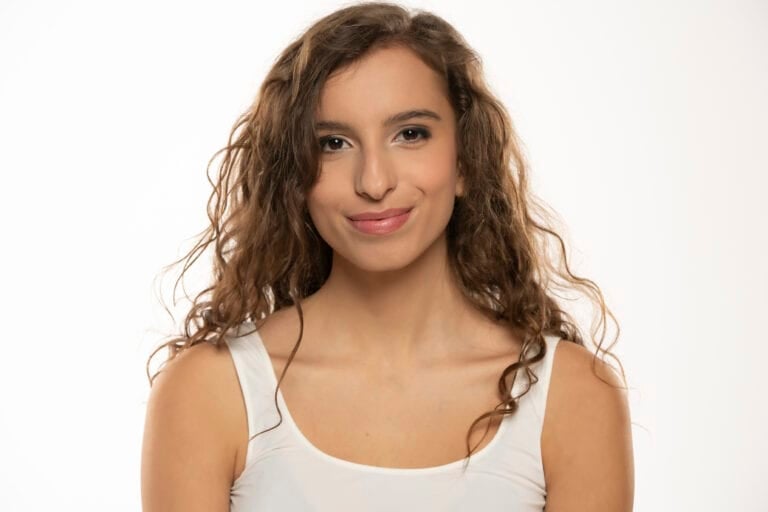 Portrait of a young smiling woman with makeup and long wavy hair